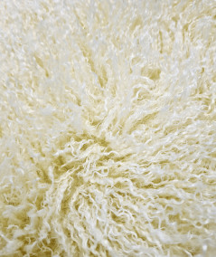 Close up image of the Mongolian curly cream faux fur fabric